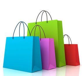 Un grupo de bolsas de compras coloridas apiladas una encima de otra sobre una superficie blanca.