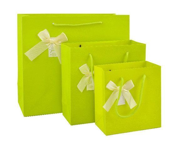 Tres bolsas de color verde lima con lazos blancos.