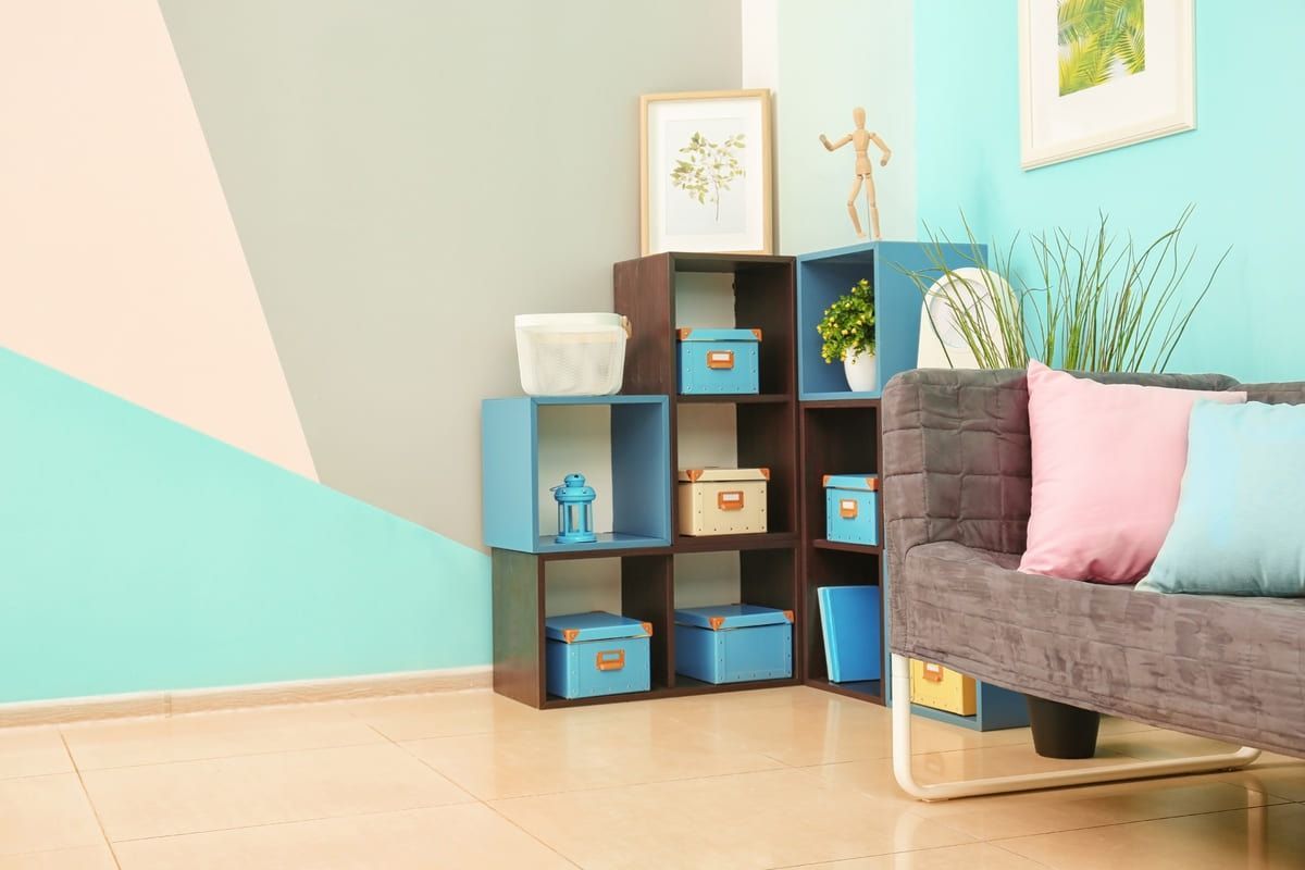 Una sala de estar con un sofá, estantes y cajas en el suelo.