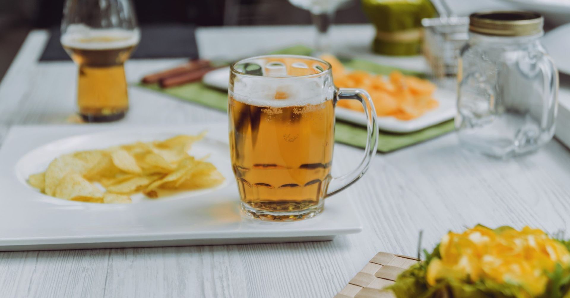 Una fila de vasos llenos de cerveza están colocados en una barra.