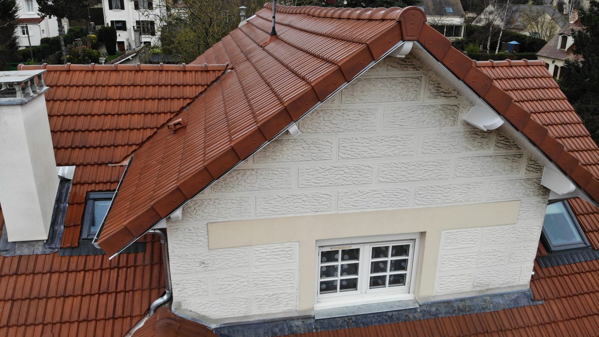 Lucarne avec façade blanche et toiture en tuiles