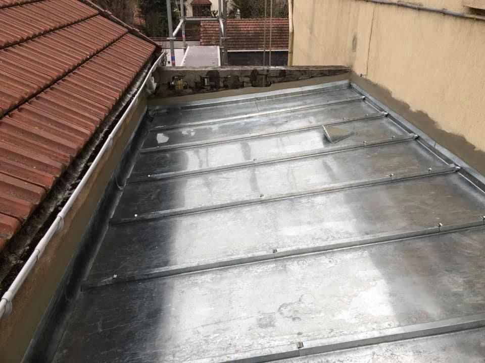 Toiture plate en zinc entre deux maisons