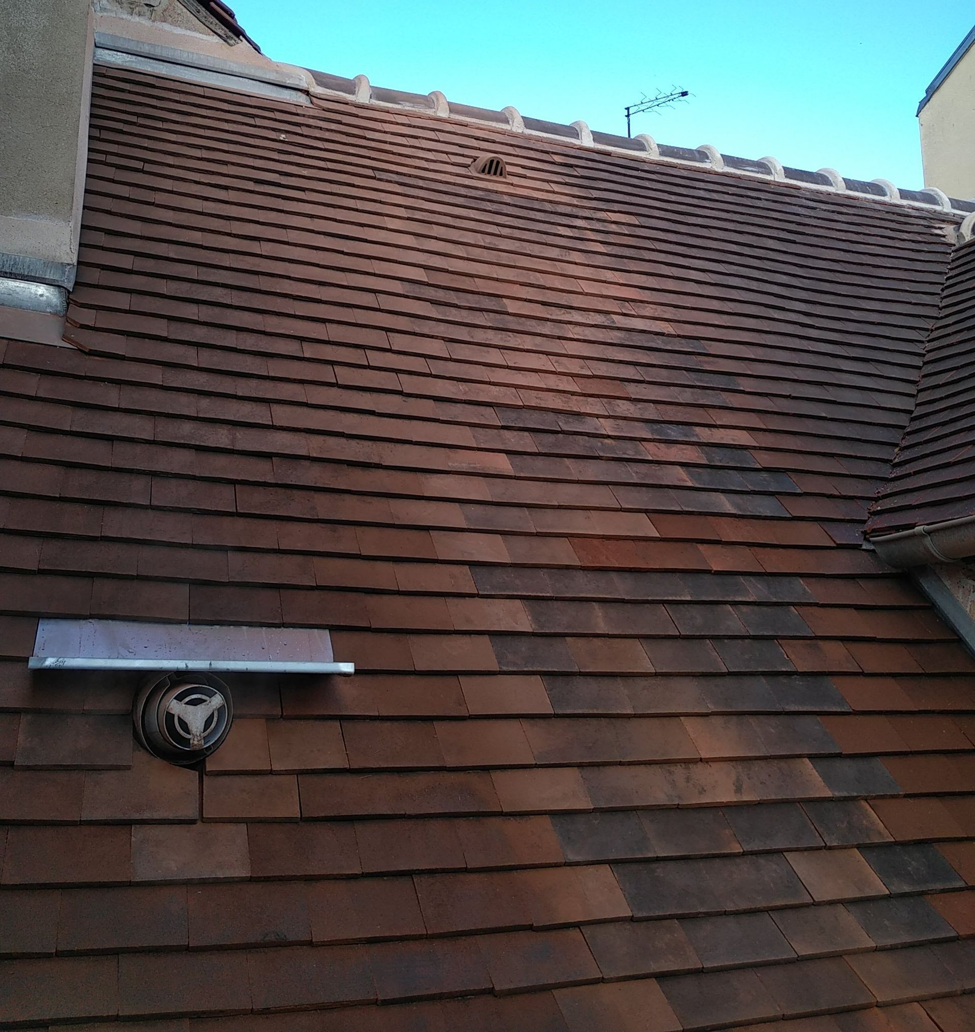 Repose de nouvelles tuiles sur un toit de maison