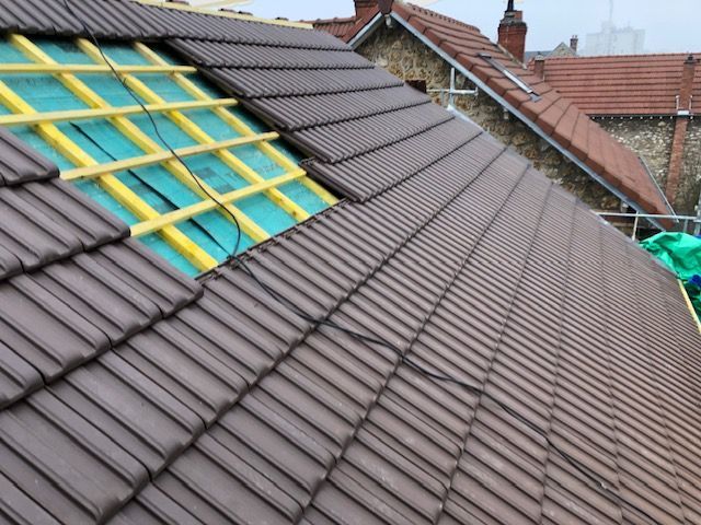 Pose des tuiles marrons sur le toit