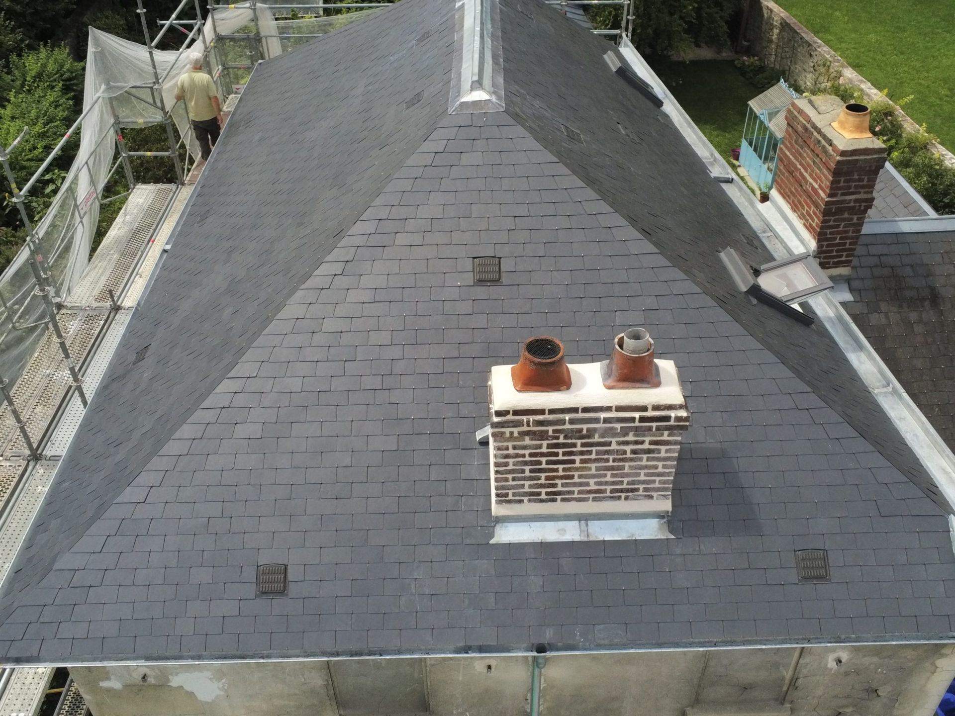 Vue de côté du grand toit de maison rénové en ardoises