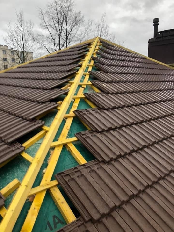 Éléments de charpente sous une toiture en tuiles