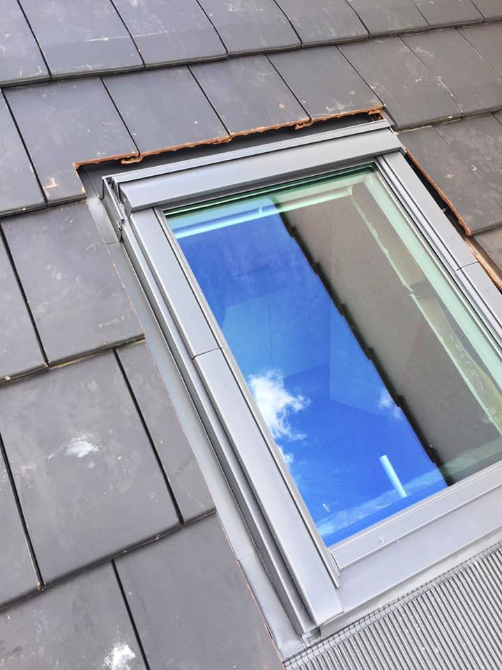 Petite fenêtre de toit sur un toit en ardoises