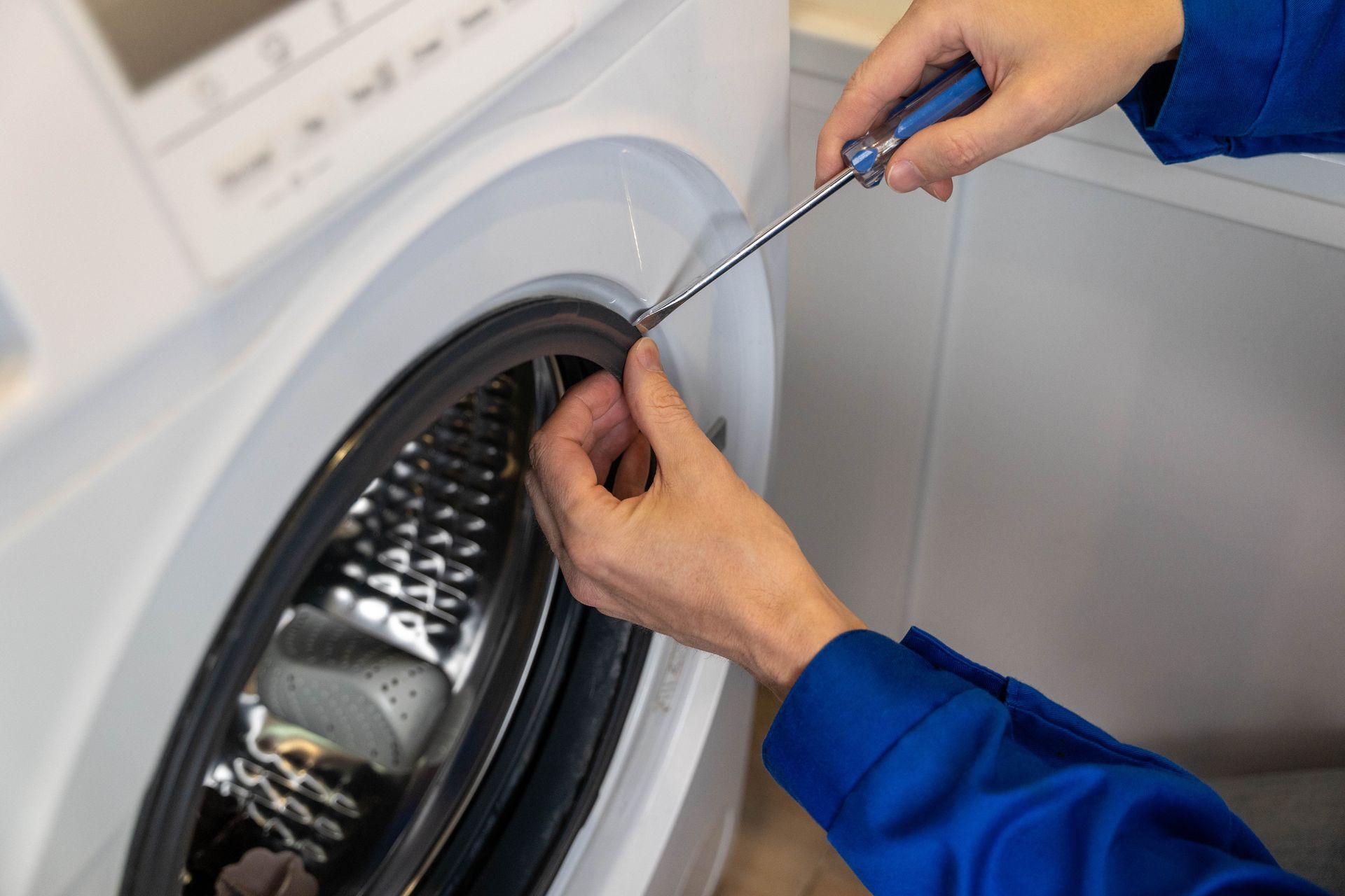 Rangée de machines à laver industrielles dans une laverie automatique.
