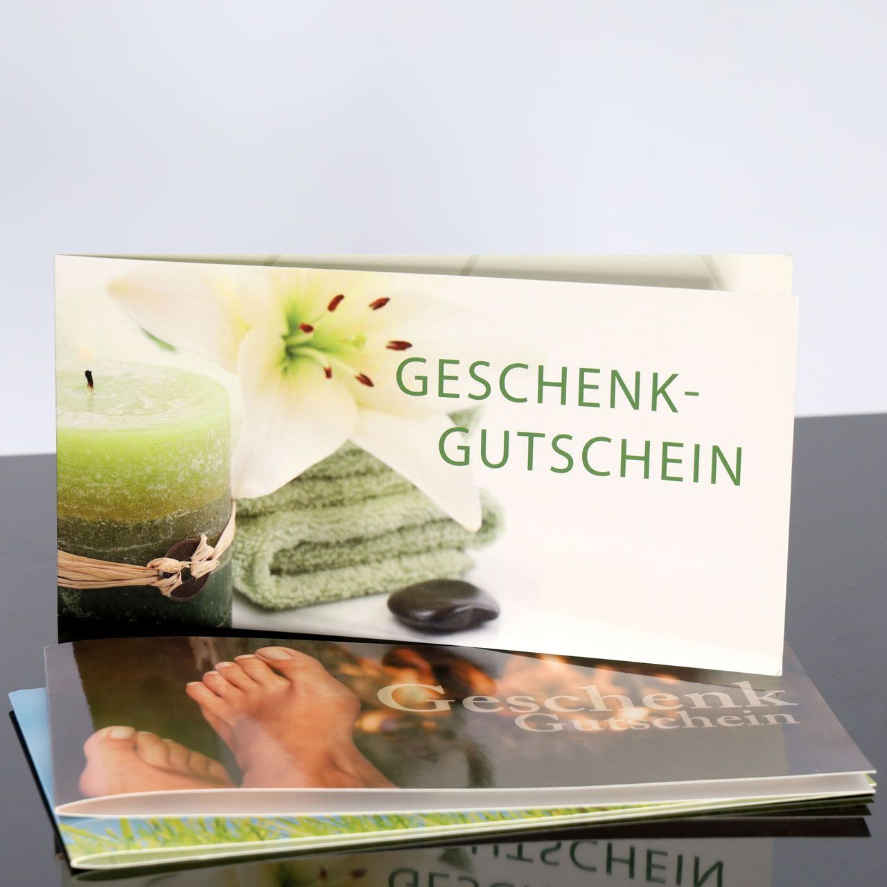 Geschenkgutschein mit dem Bild der Füße einer Person und einer Kerze darauf.