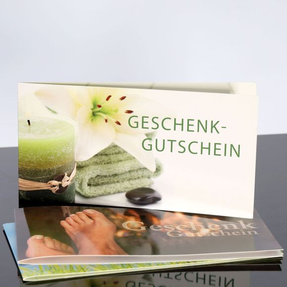 Geschenkgutschein mit dem Bild der Füße einer Person und einer Kerze darauf.