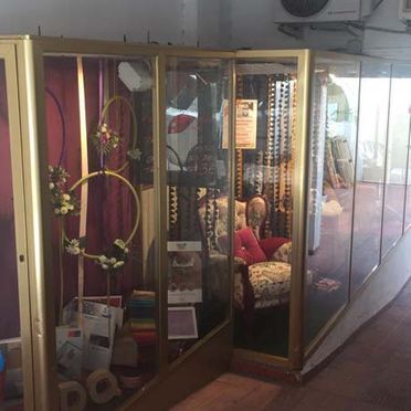 Vitrinas con objetos decorativos en exposición, entre ellos coronas y una silla.