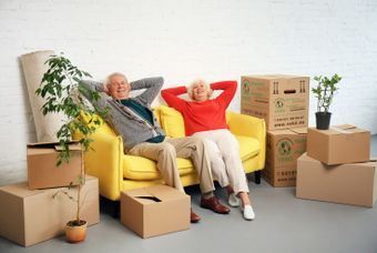Zwei Senioren sitzen auf einem gelben Sofa