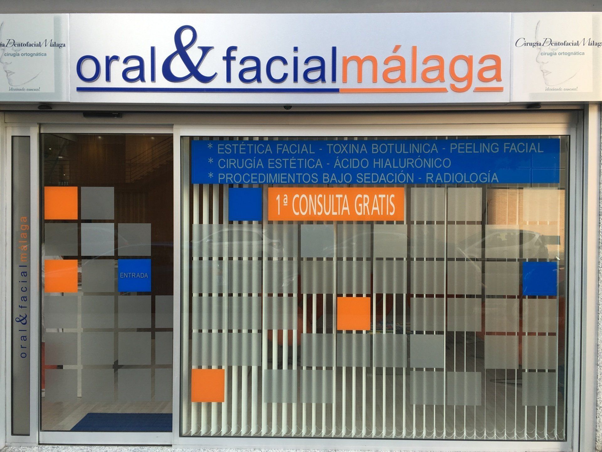 Letrero de una clínica dental y facial en Málaga que ofrece servicios de estética facial. Incluye 