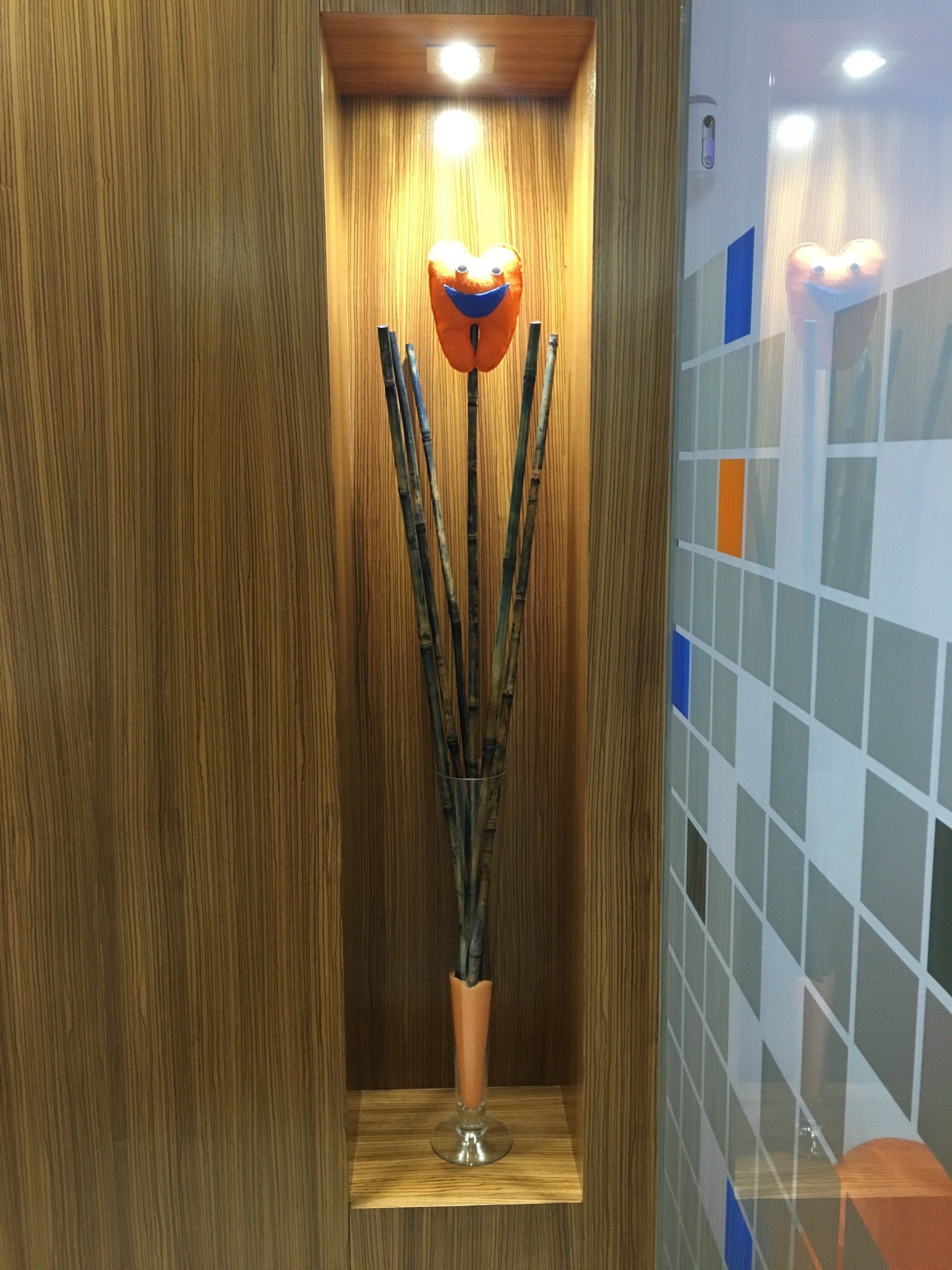 Alcoba de madera con escultura de flor de metal y luz.