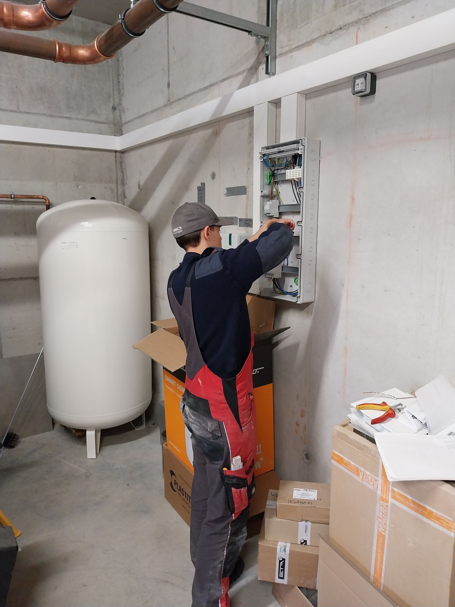 Elektrotechnik-Azubi an einem Stromkasten