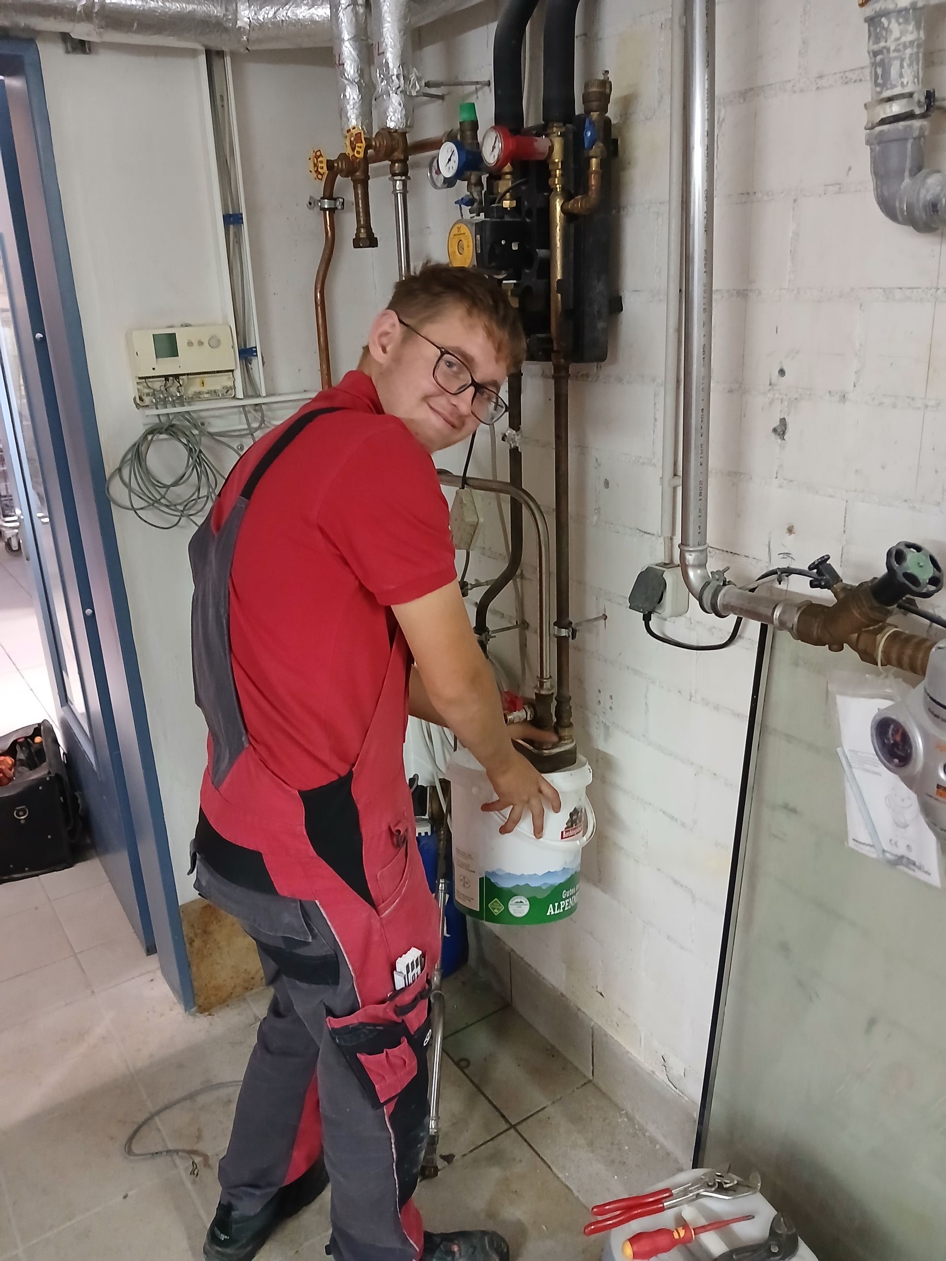 Azubi für Sanitär und Heizung beim Sanieren einer Heizungsanlage