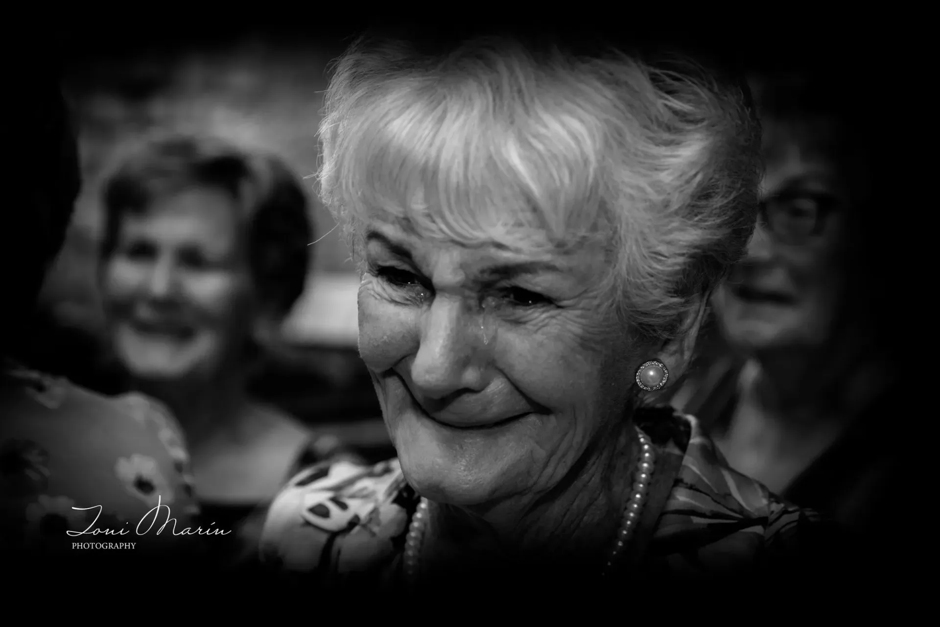 Una mujer mayor sonríe en una foto en blanco y negro.