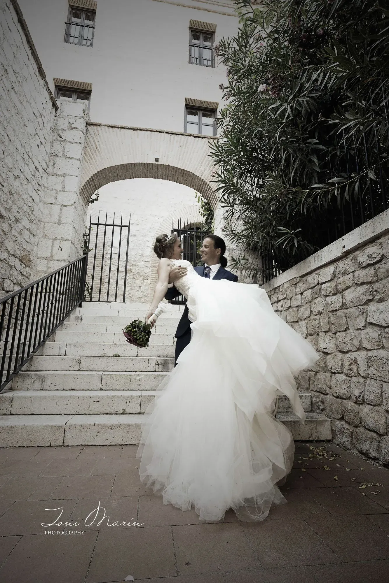 Una novia y un novio posan para una foto en unas escaleras.