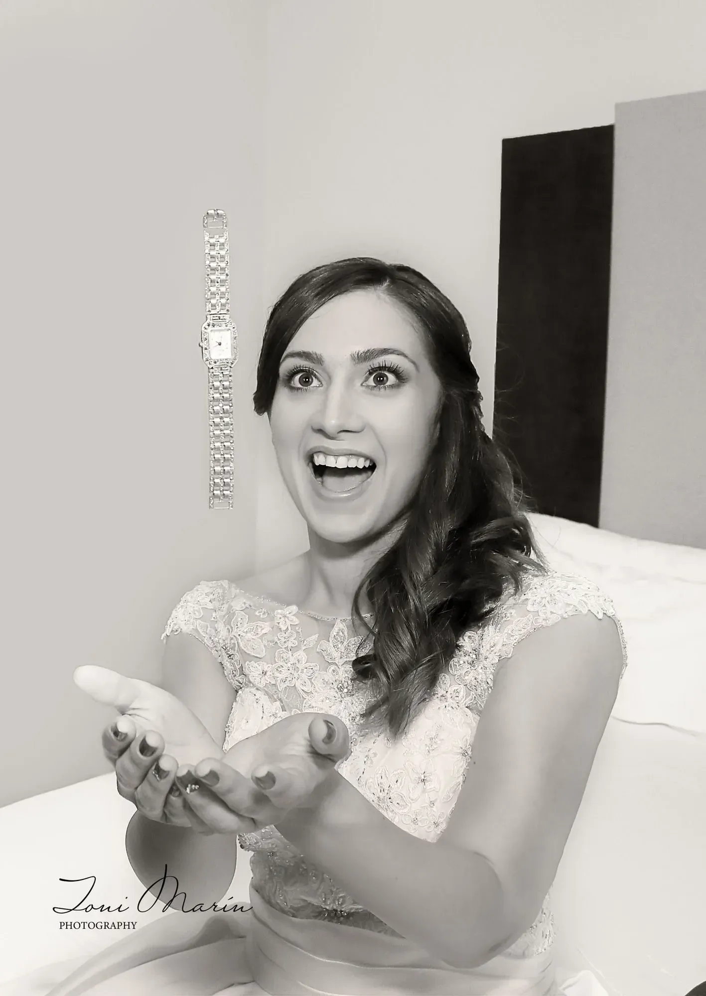 Una mujer con un vestido de novia está sentada en una cama sosteniendo un control remoto.