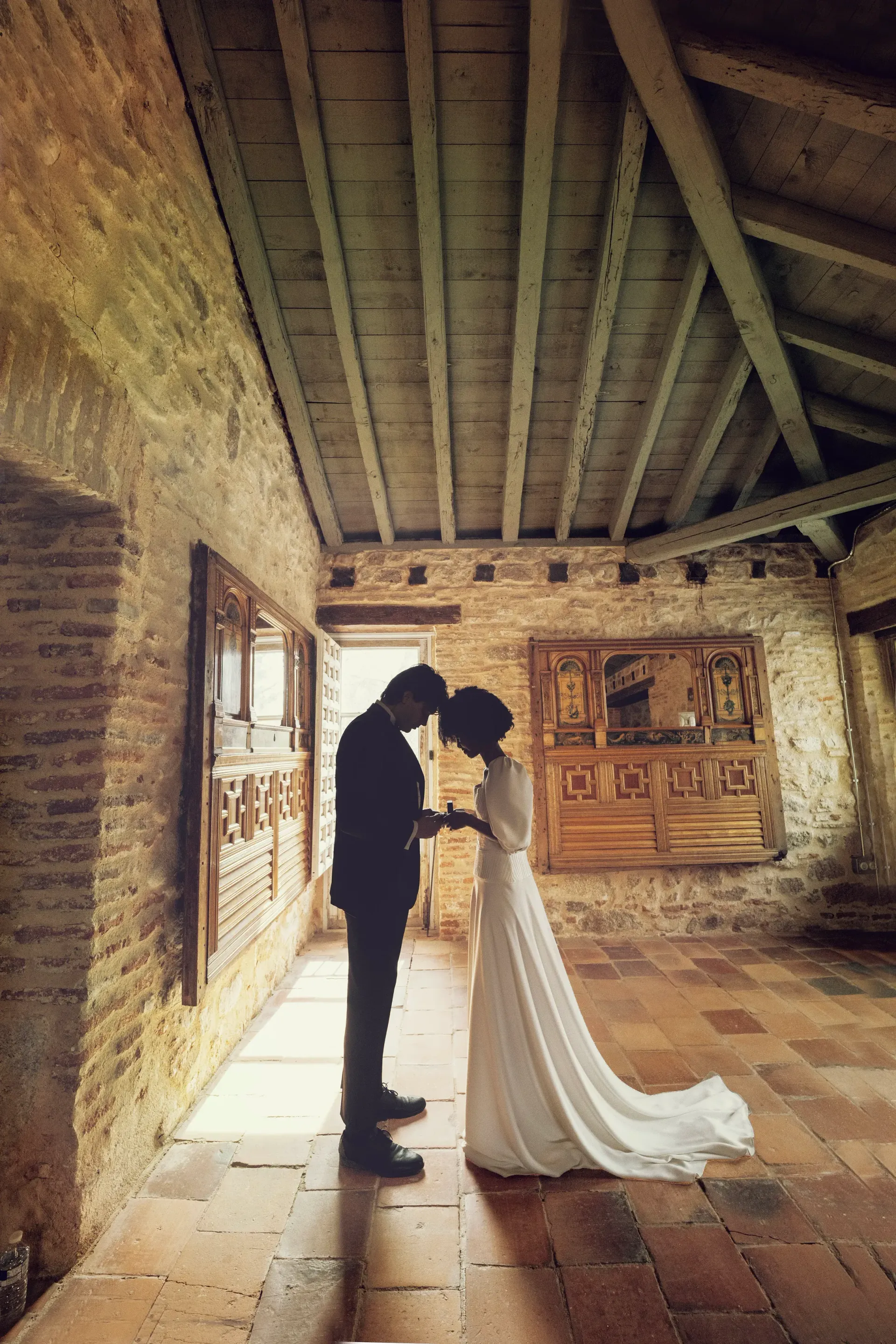 Una novia y un novio están de pie uno al lado del otro en una habitación.