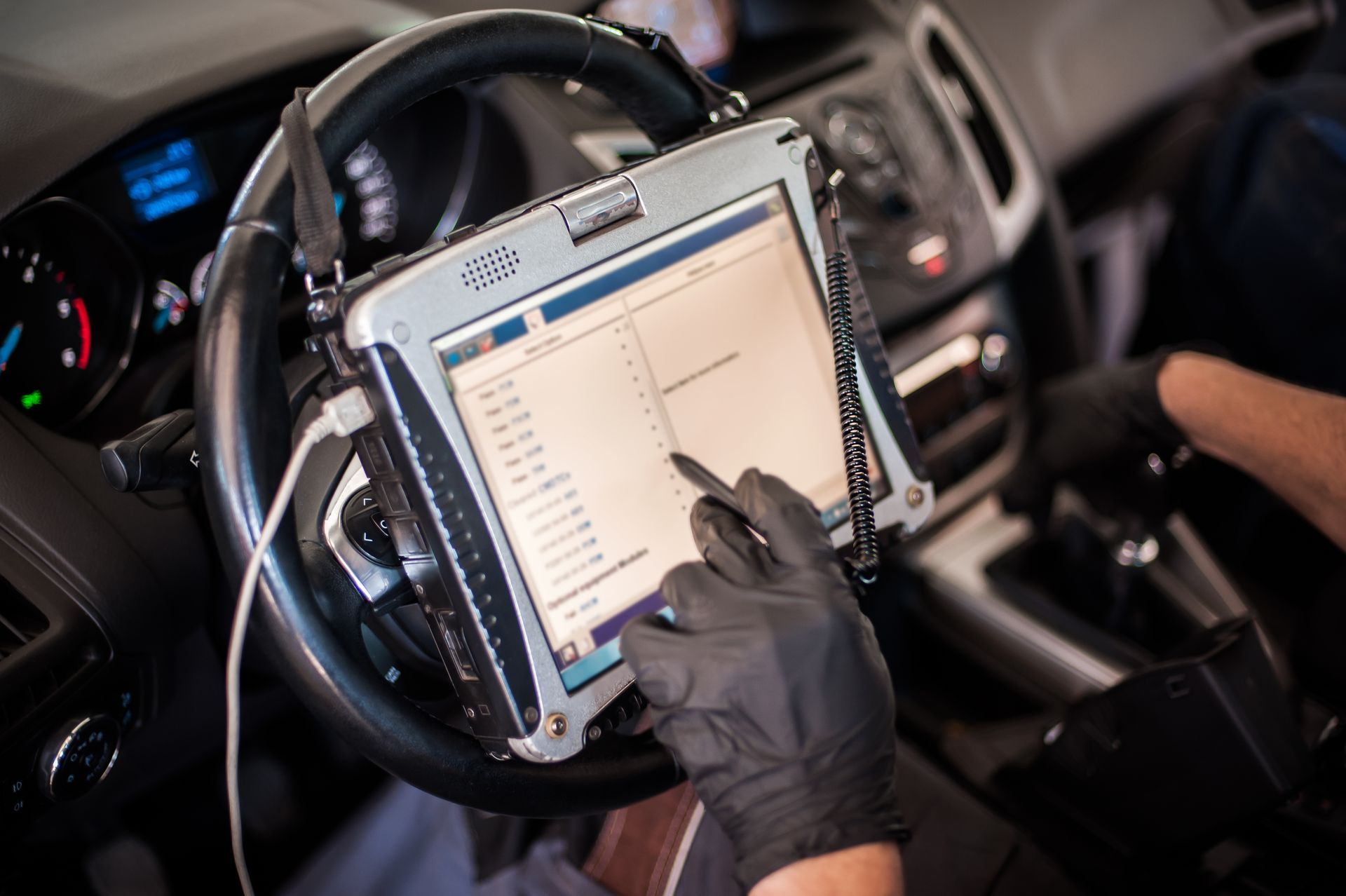 Mécanicien qui passe une voiture à la valise pour un diagnostic auto
