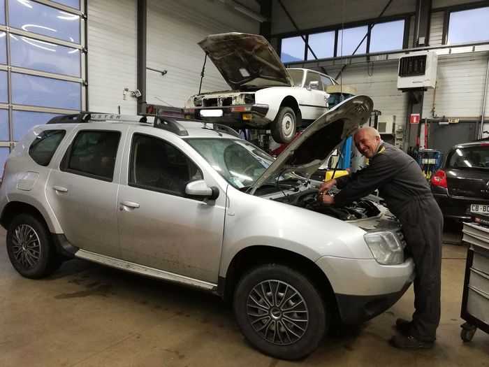 Mécanicien qui répare une voiture dans un garage
