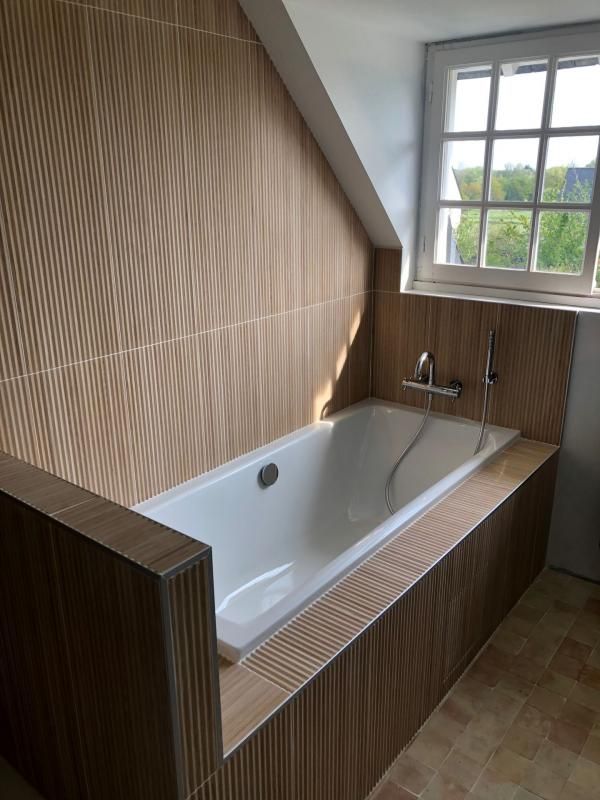 Pose de carreaux marron rayés autour d'une baignoire