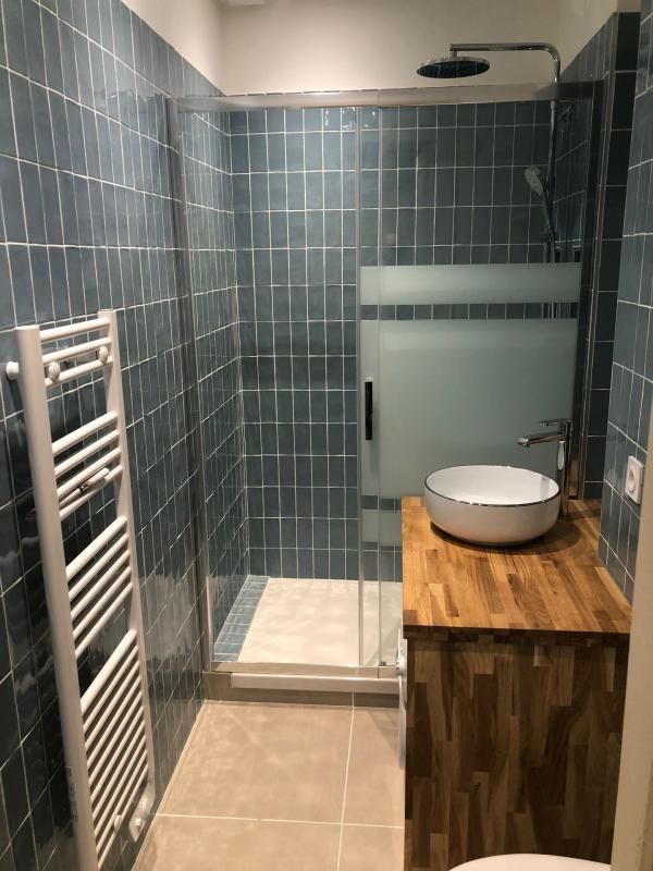 Salle de bains avec un sol en carrelage beige et murs en crédence verte