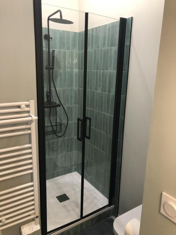 Petits carreaux verts à l'intérieur d'une douche