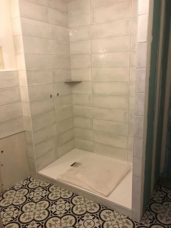 Pose de mosaïque avec des motifs au sol d'une salle de bains