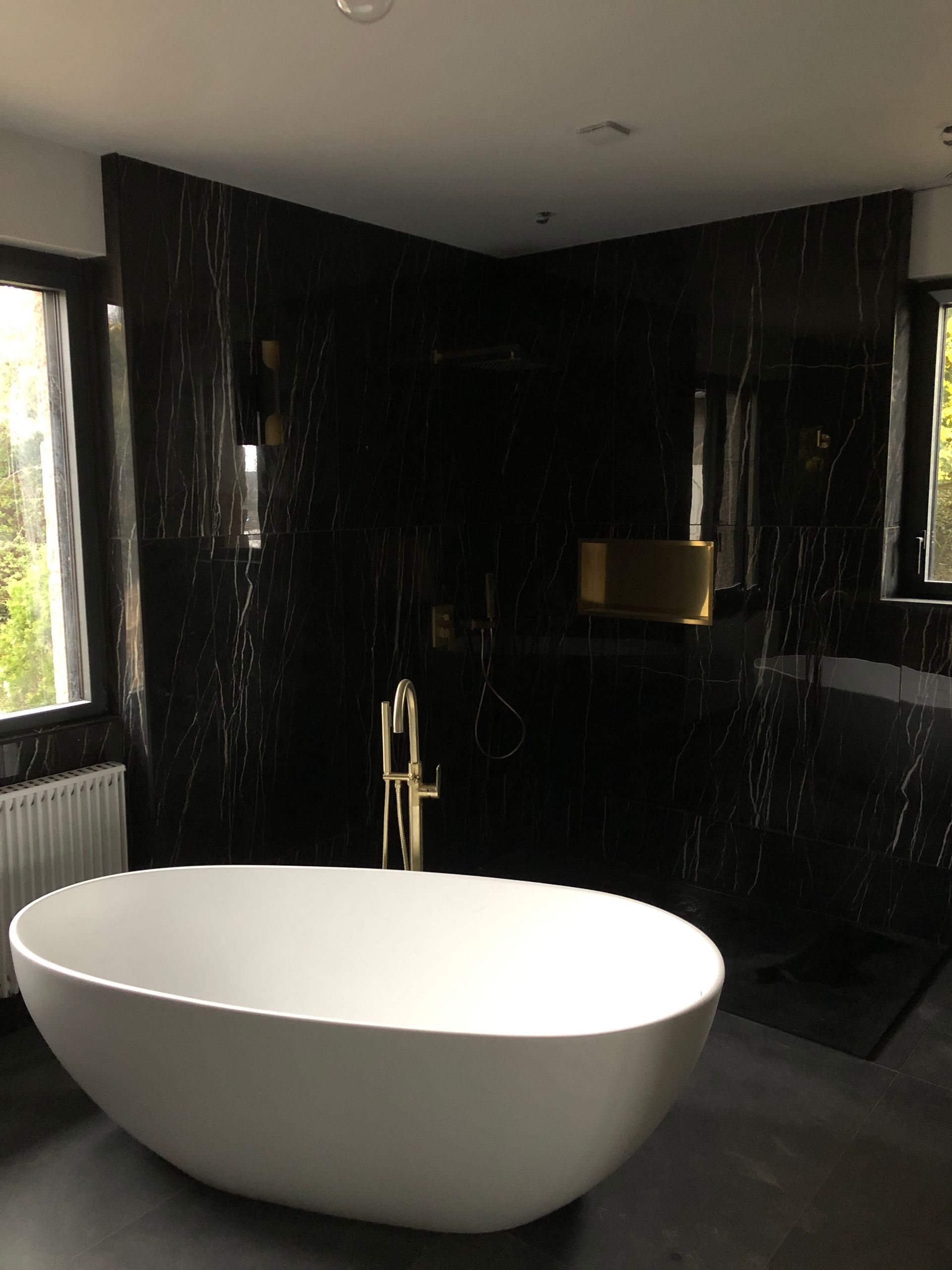 Pose de carreaux noirs sur les murs d'une salle de bains