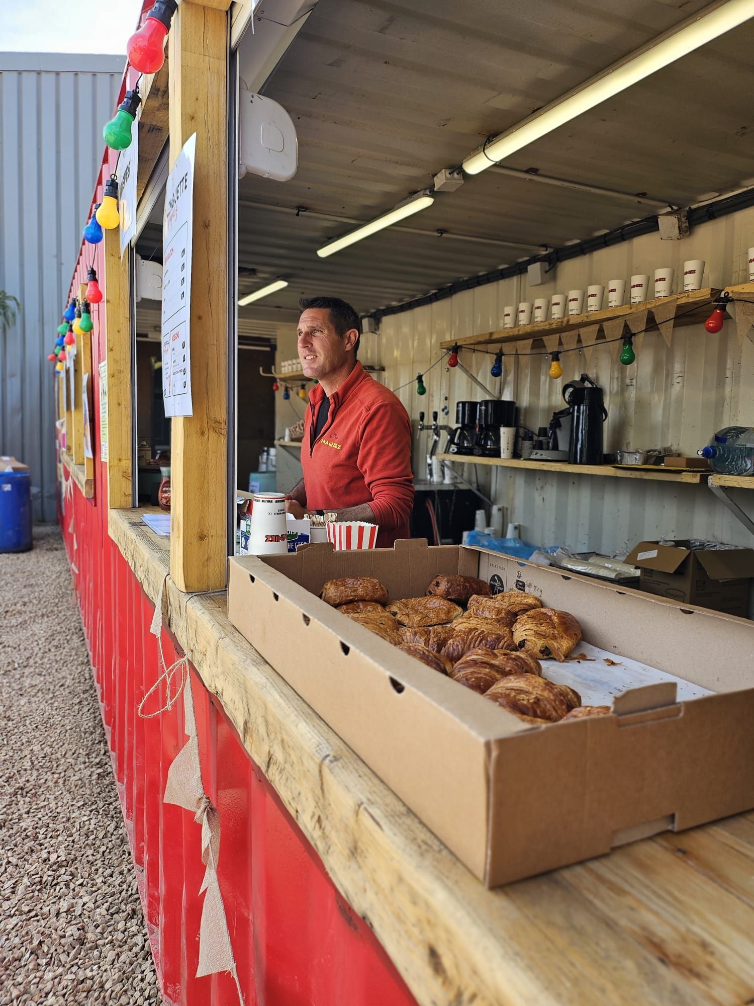 Homme derrière un stand avec des viennoiseries devant lui