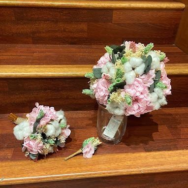 Dos ramos de flores están sentados en una escalera de madera.