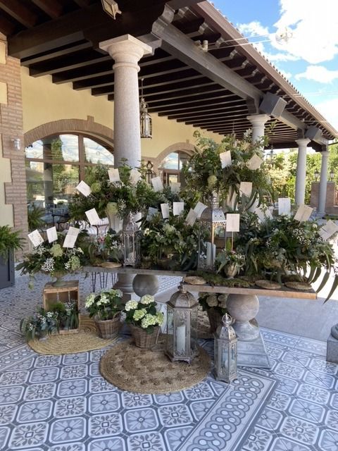 Una mesa con flores y velas debajo de un porche cubierto.