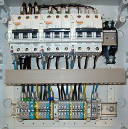 Un primer plano de una caja eléctrica con muchos cables saliendo de ella.