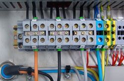 Un primer plano de una caja eléctrica con un montón de cables conectados a ella.
