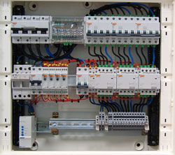 Un primer plano de una caja eléctrica con muchos cables saliendo de ella.