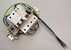 Un primer plano de un disyuntor con cables conectados a él sobre una mesa.