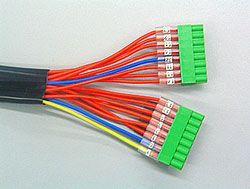 Un montón de cables están conectados entre sí sobre una superficie blanca.