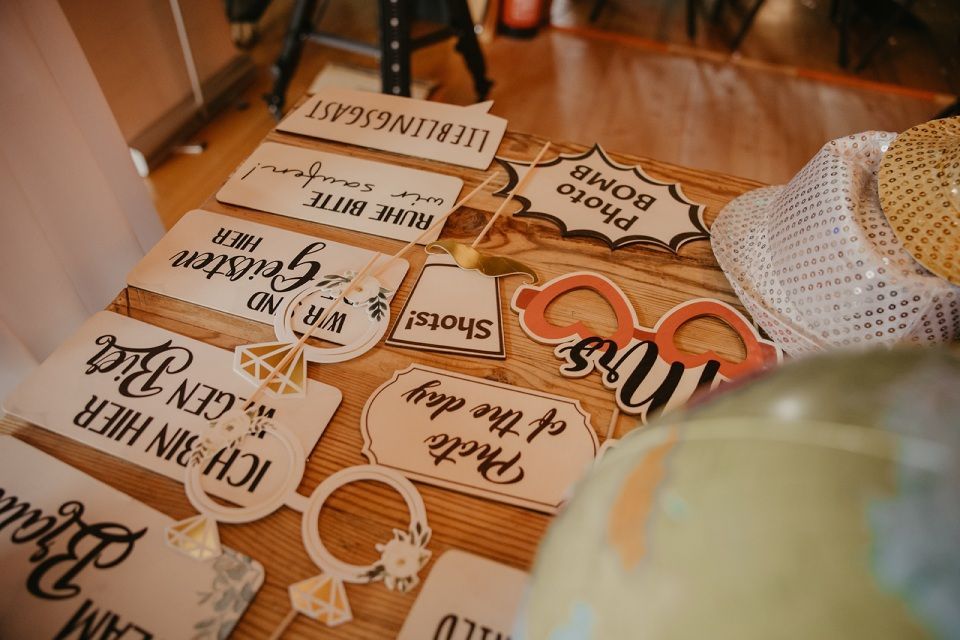 Requisiten für eine Hochzeitsfotobox auf einem Holztisch.