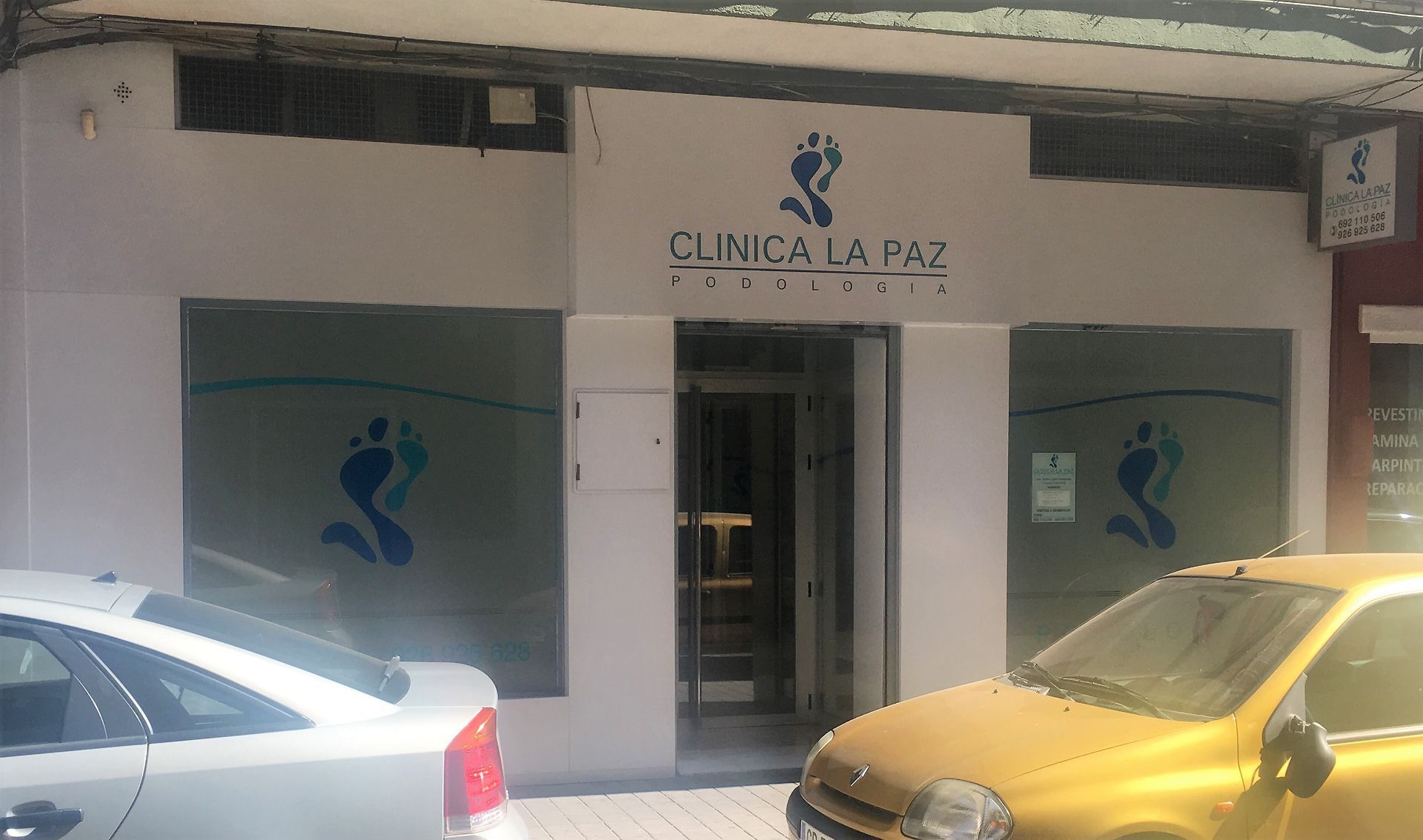 Un coche amarillo está estacionado frente a la Clínica La Paz.