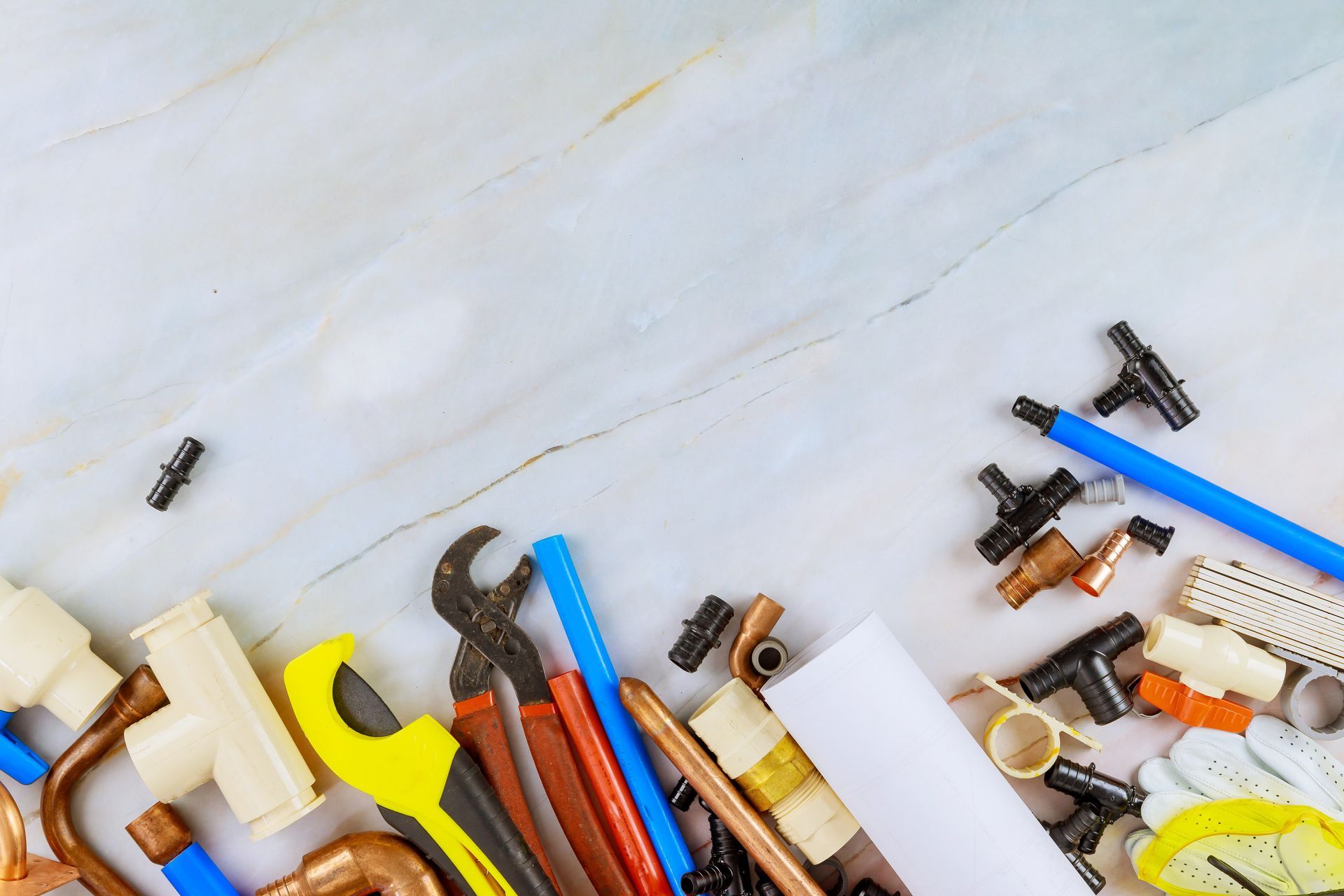 Des outils à main, notamment des clés et des tournevis, sont éparpillés sur une surface blanche.