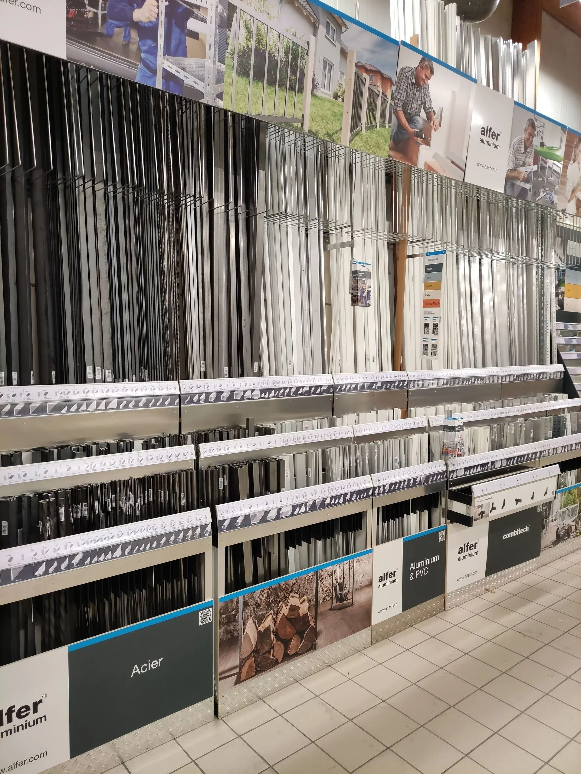 Allée du magasin avec des rangées d'articles à rayures noires et blanches suspendus et des produits emballés sur les étagères.