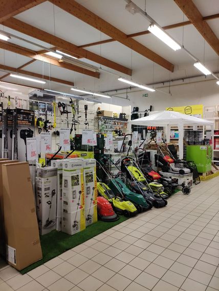 Allée d'un magasin de détail présentant des sacs de golf, des clubs et des accessoires sous un éclairage vif au plafond