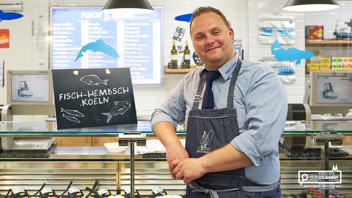Ein Mann in einer Schürze steht vor einer Theke mit einem Schild mit der Aufschrift 