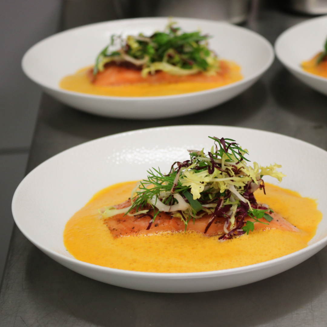 Auf einem Holztisch steht ein Tablett mit Essen.