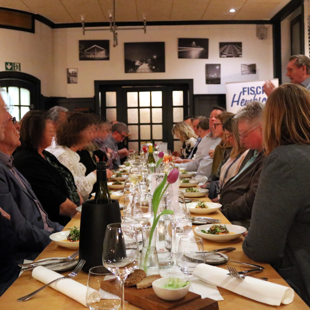 Drei Männer stehen um einen Tisch herum , auf dem eine Schachtel mit Essen steht.
