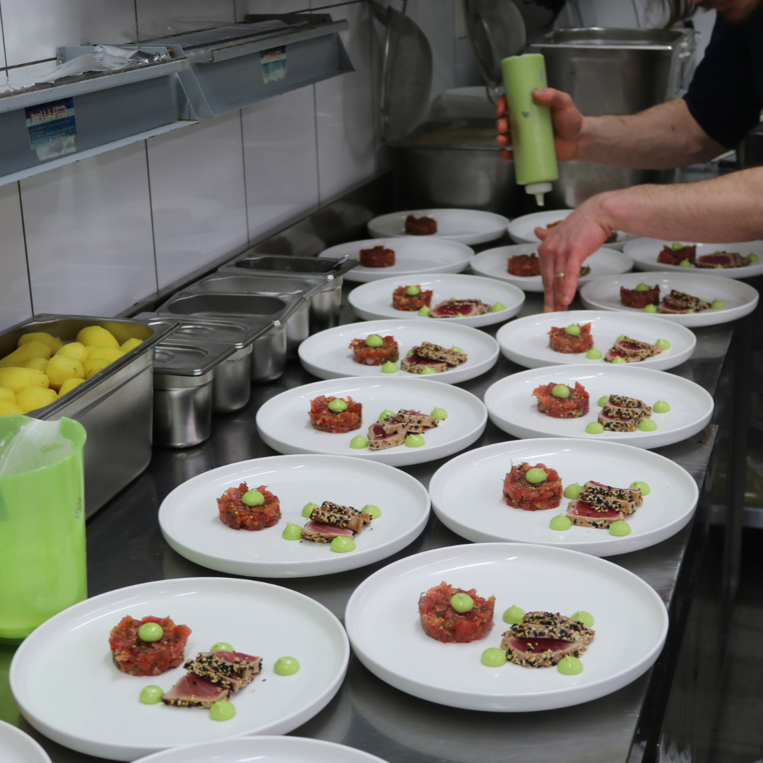 Auf einem Holzboden steht ein Wagen voller Kisten mit Lebensmitteln.
