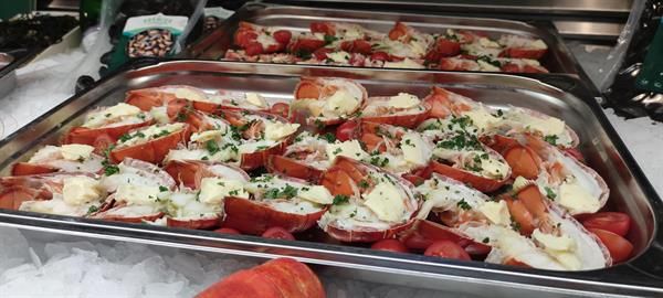 Ein Tablett mit Hummern mit Butter und Schnittlauch auf Eis.