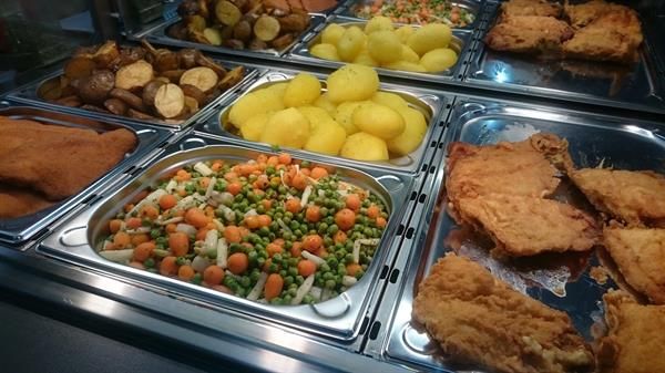 Ein Buffet mit verschiedenen Speisen, darunter Kartoffeln und Gemüse.